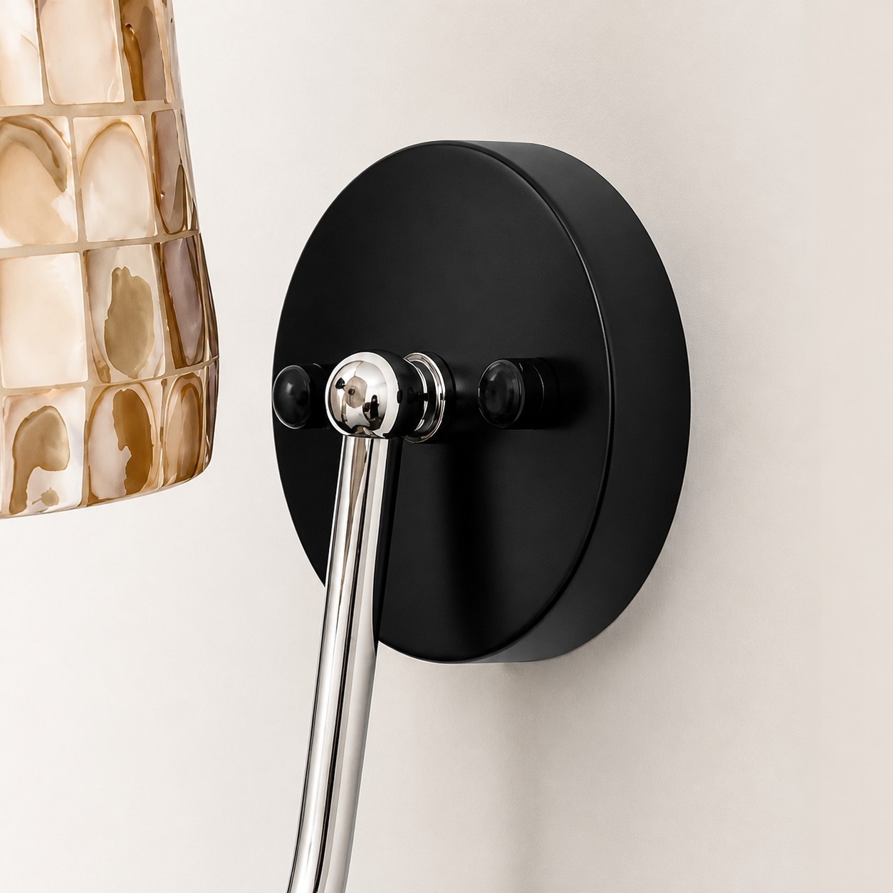 Close view of black wall plate and chrome curved arm
