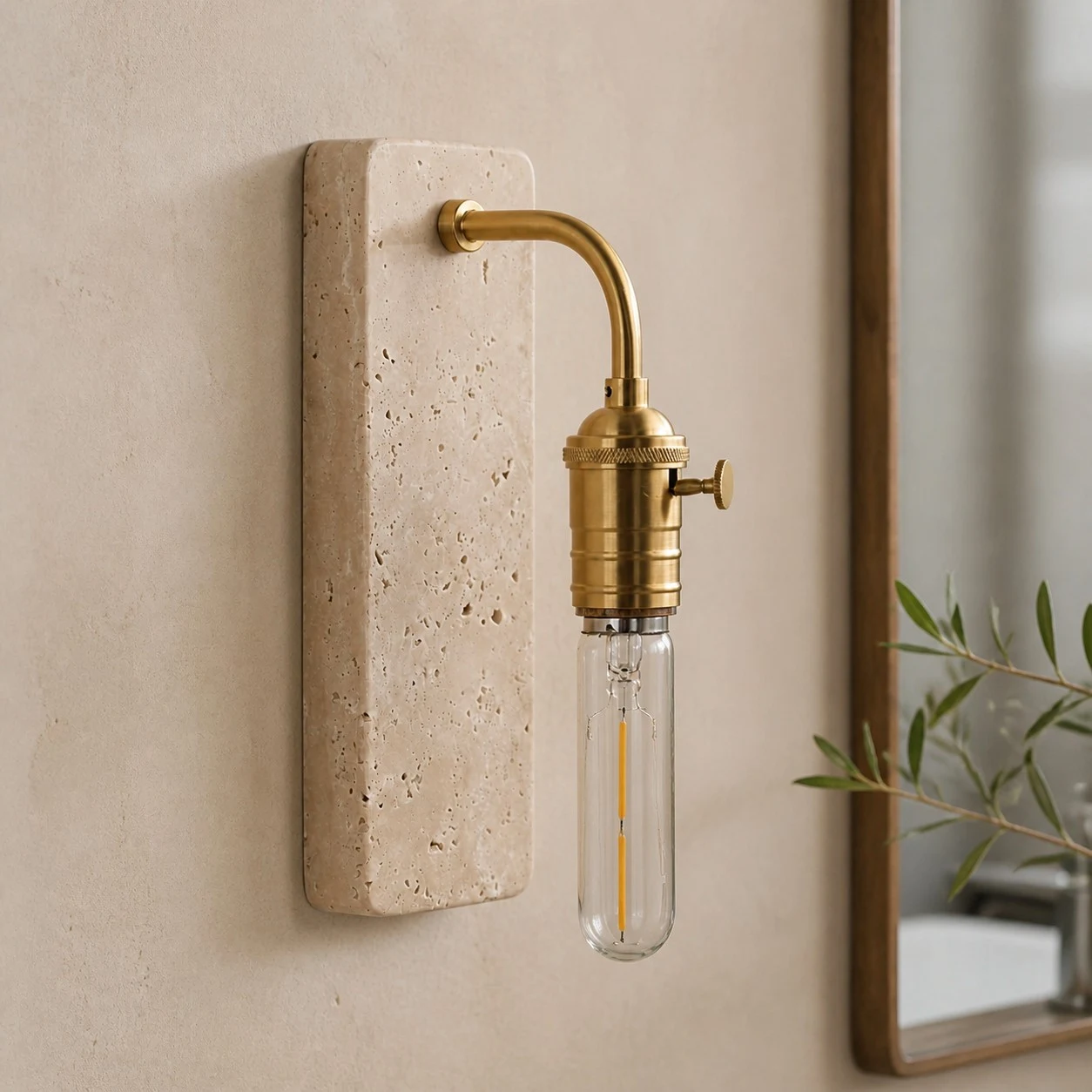 Gold travertine wall sconce installed beside a mirror