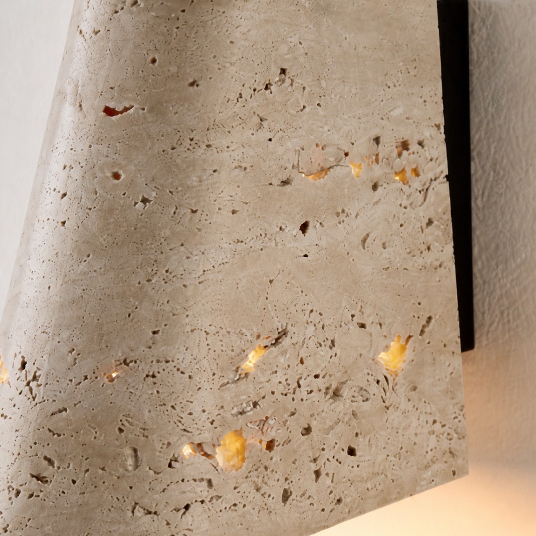 Travertine shade beside the dark metal wall plate