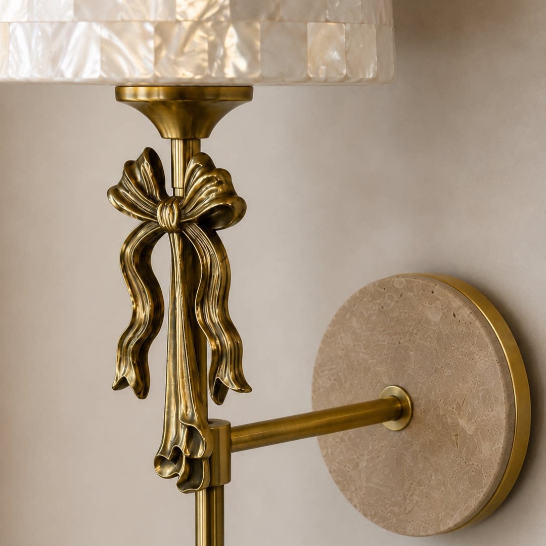 Close view of the sculpted metal bow and travertine wall plate