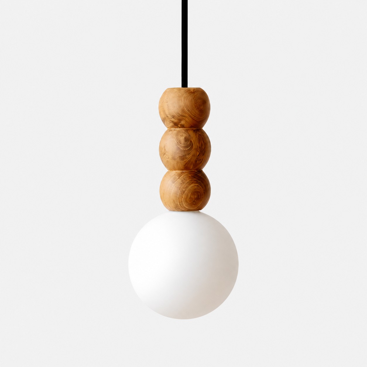 Sculptural three-bead wood pendant light with a frosted glass globe on white