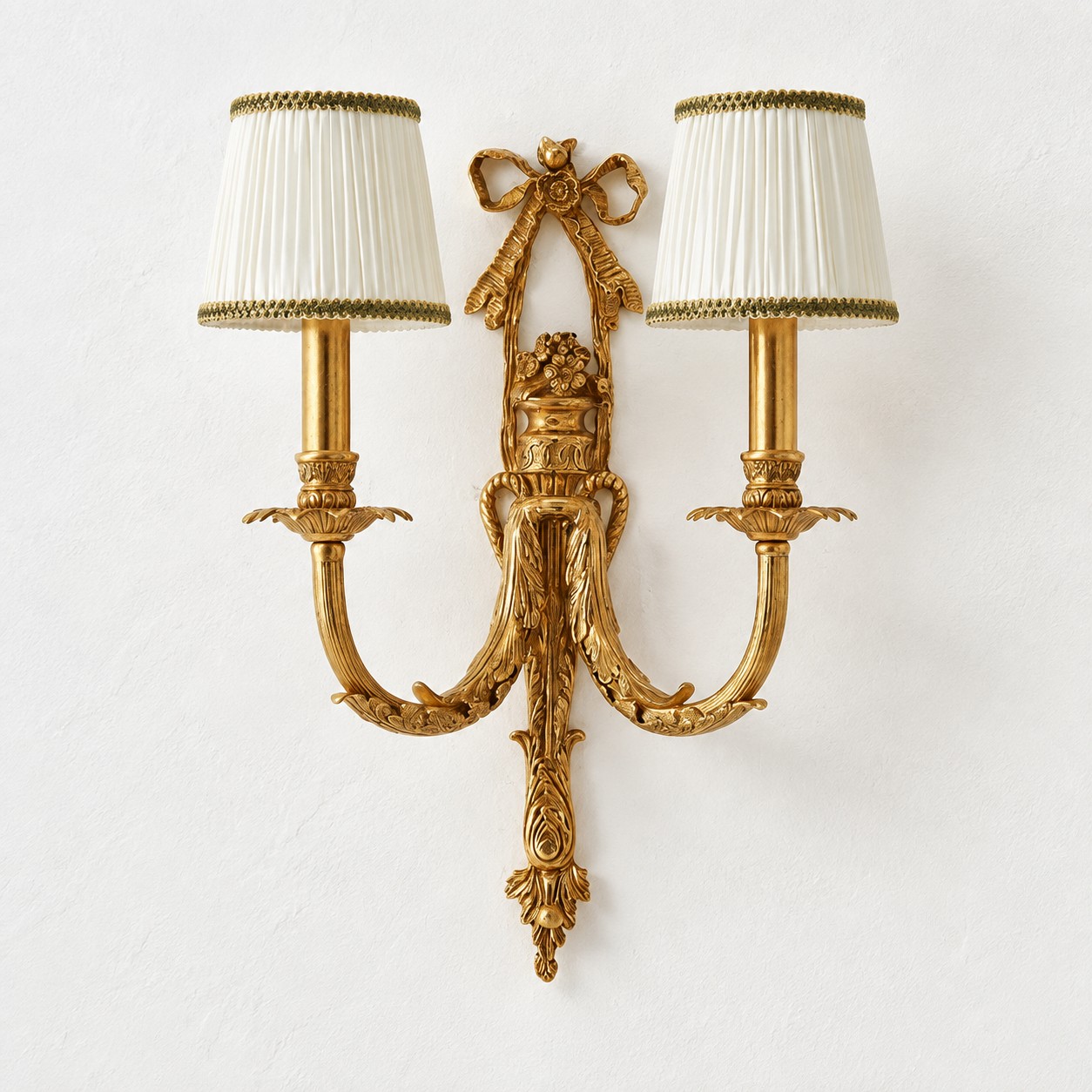 Two-head brass wall sconce with white pleated fabric shades